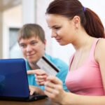 couple buying online with laptop and credit card at home