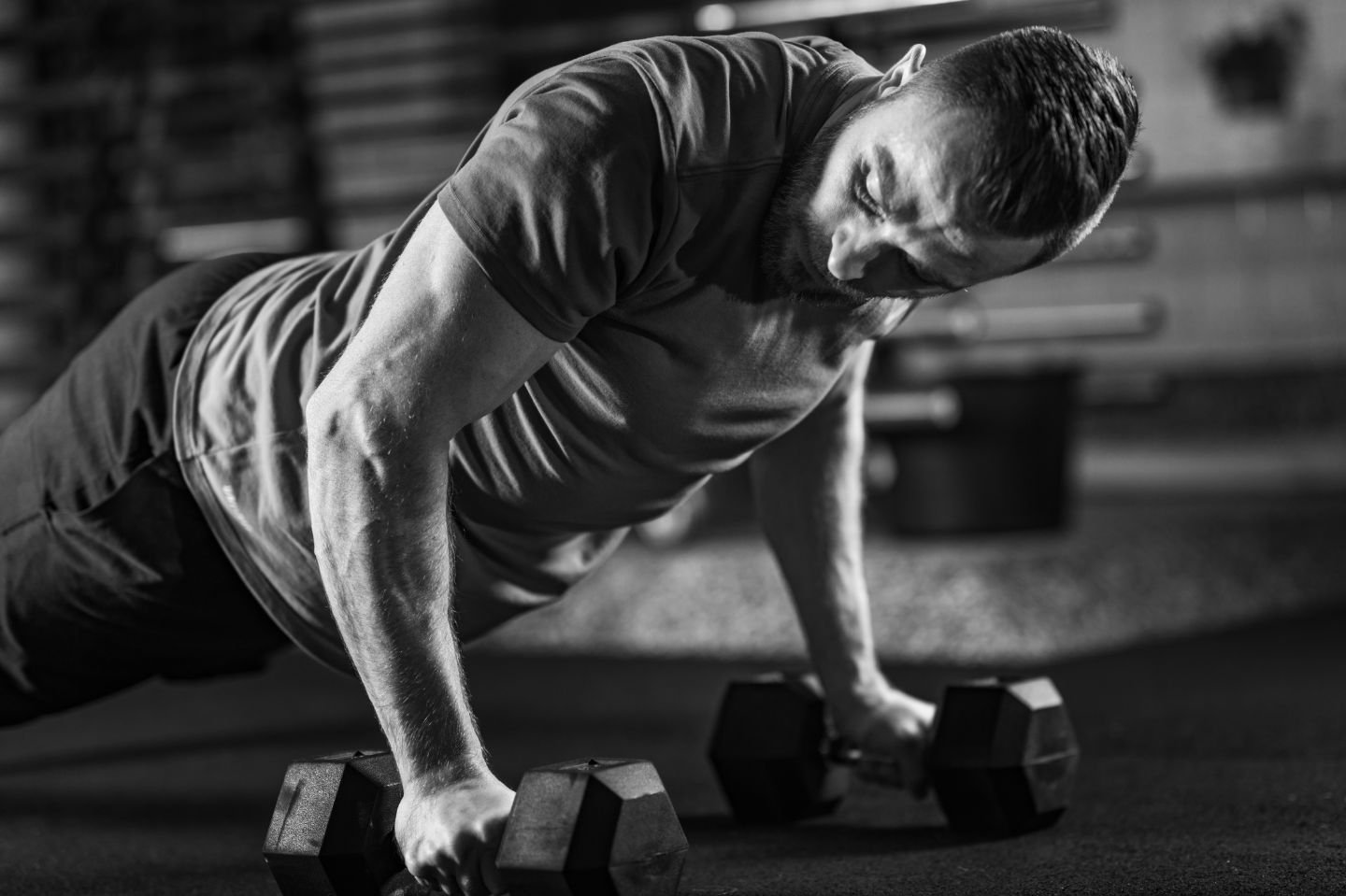 Man performing strength training push-up with dumbbells – Bodywork Chevy Chase fitness and therapy concept