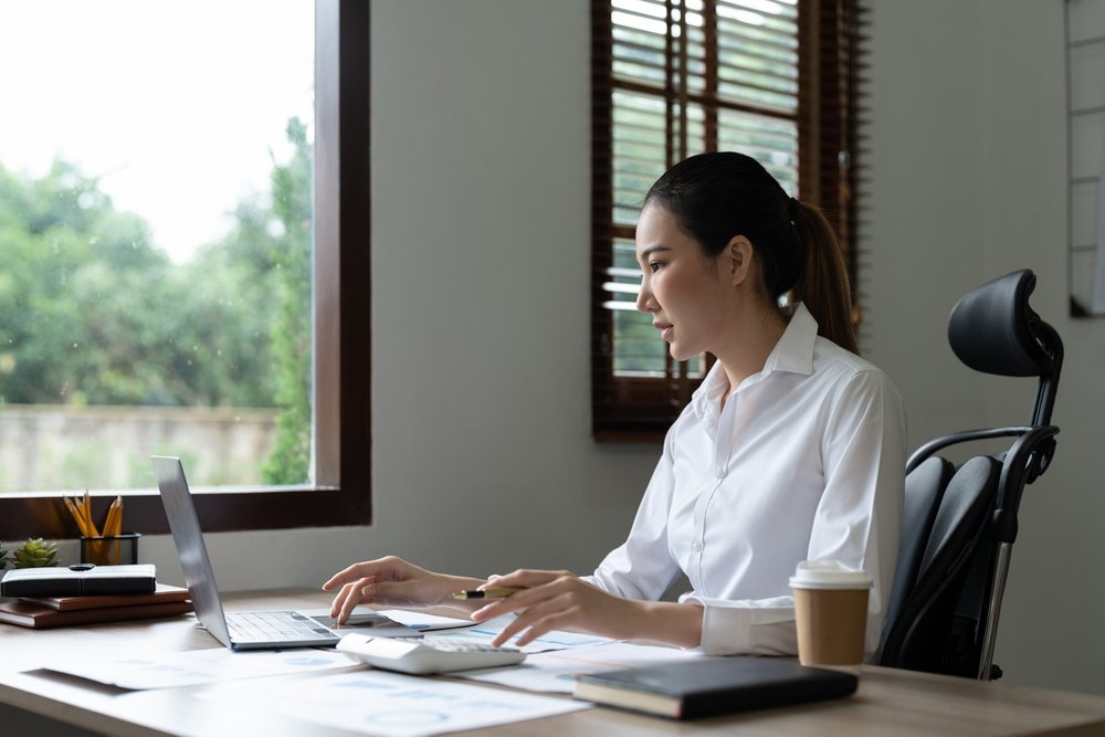 Woman,Accountant,Using,Calculator,And,Laptop,Computer,In,Office,,Finance