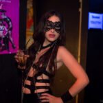 Woman wearing black lace mask and leather outfit posing at Wasteland Berlin fetish festival event