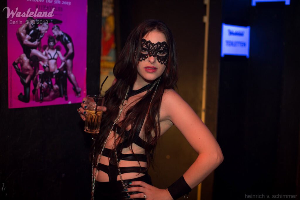 Woman wearing black lace mask and leather outfit posing at Wasteland Berlin fetish festival event