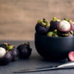 Mangosteen fruit in a black bowl