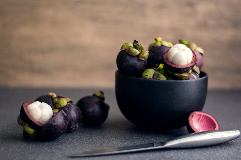Mangosteen fruit in a black bowl